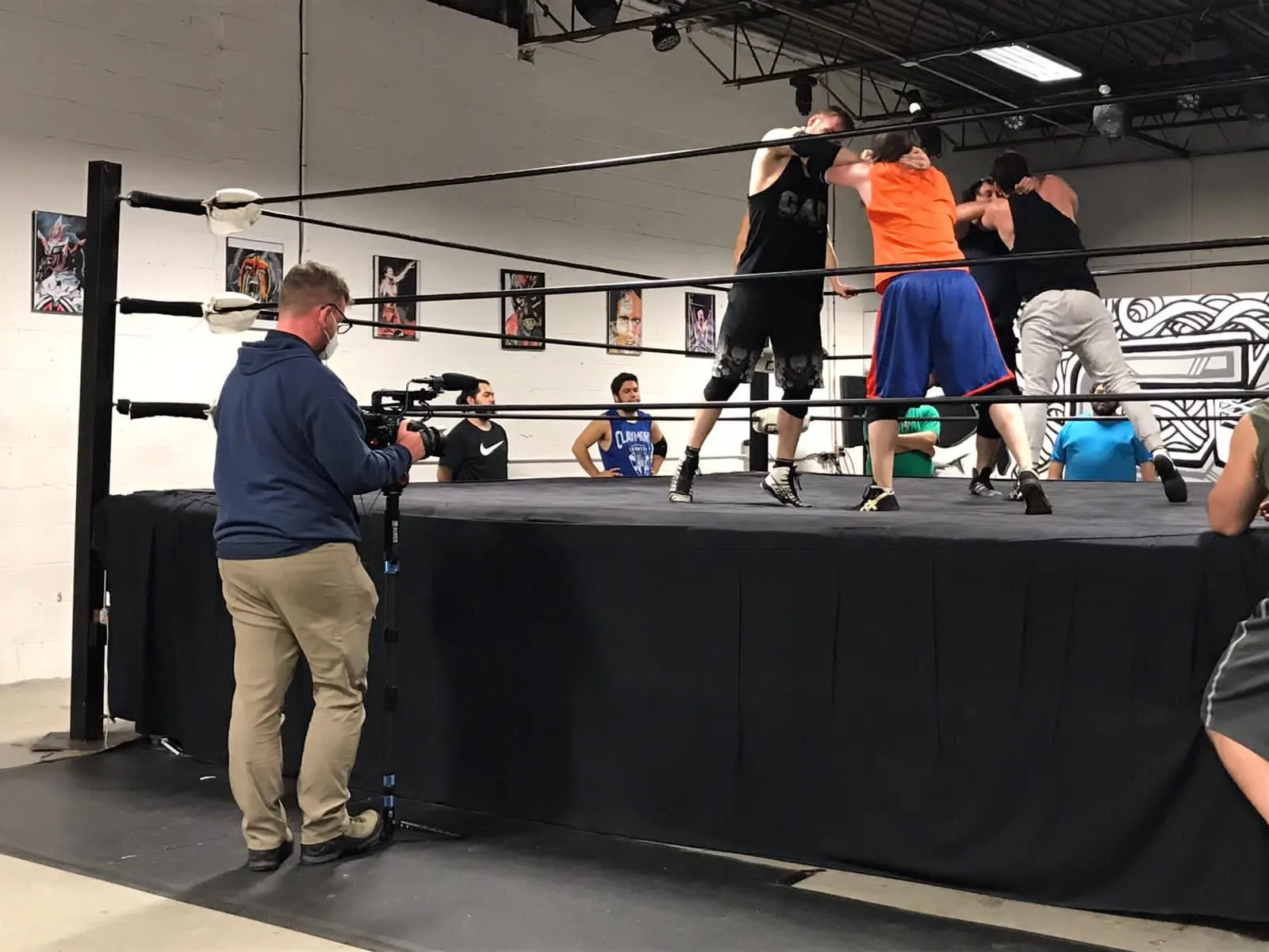 Behind the scenes filming wrestlers training in a gym